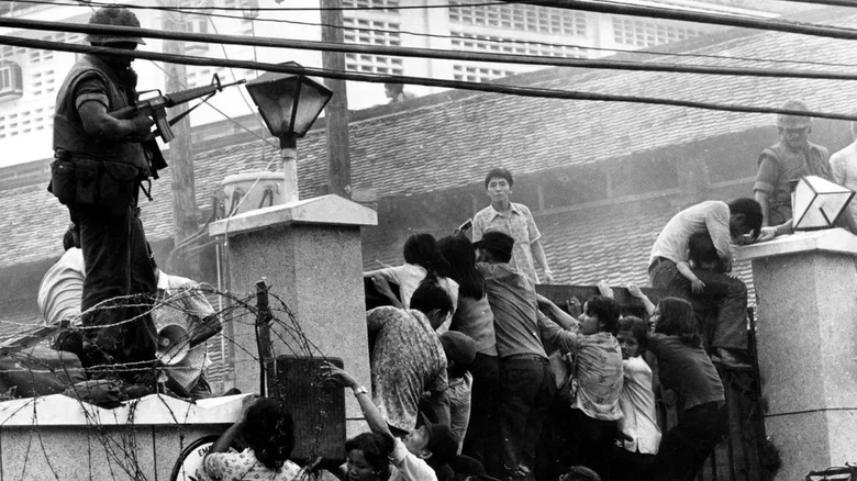 South Vietnamese civilians climbing over a large wall