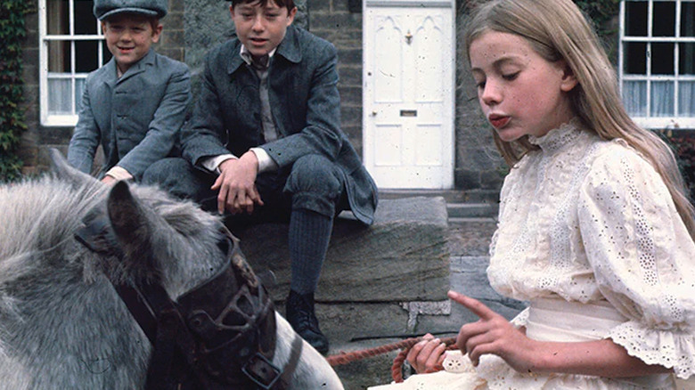 A girl attends to a pony