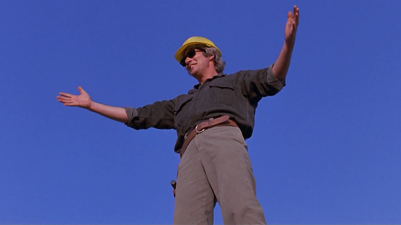 Richard Gere stands against a blue sky