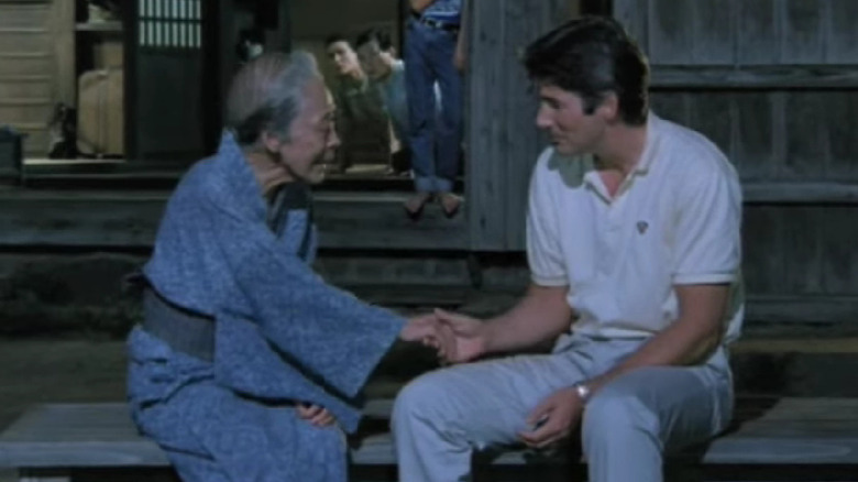 An elderly woman shakes Richard Gere's hand