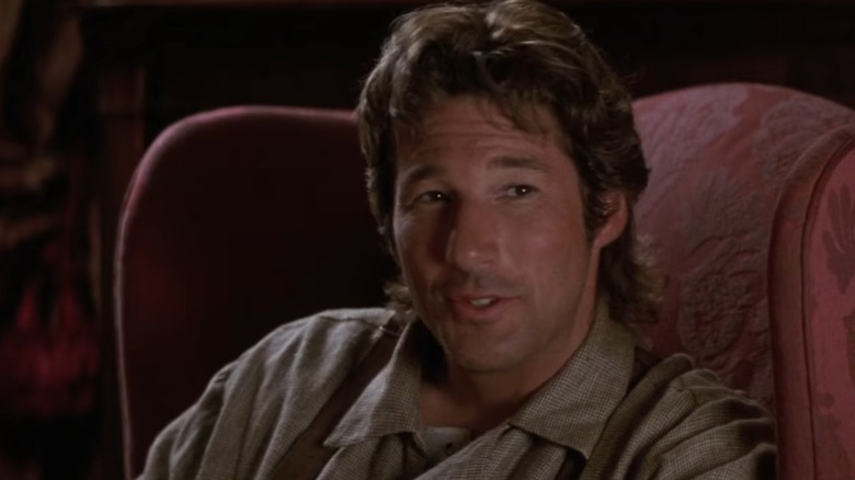 Richard Gere sits in a red chair