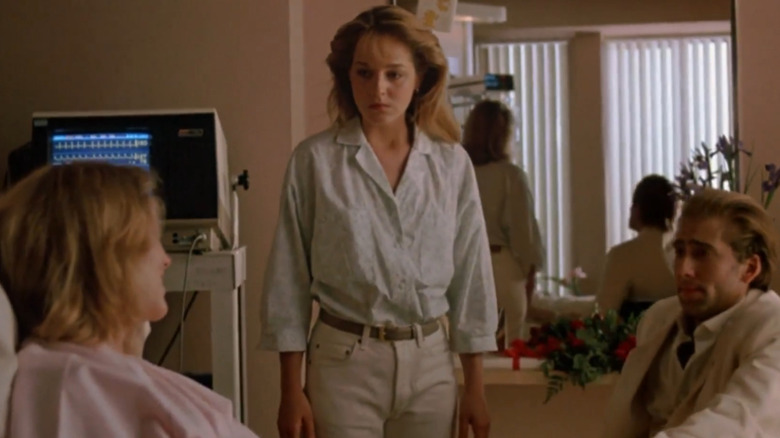 Helen Hunt and Nicolas Cage look at Kathleen Turner in a hospital bed