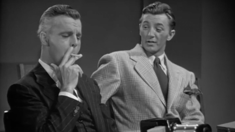 Fred Graham watches man smoke