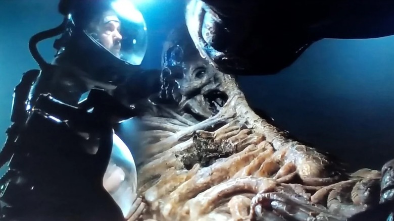 Captain Dallas investigates a dead space pilot in "Alien" (1979)