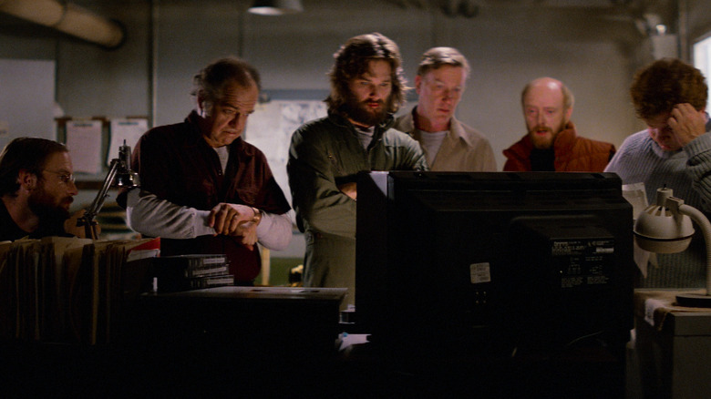 Scientists standing around computer screen in "The Thing" (1982)