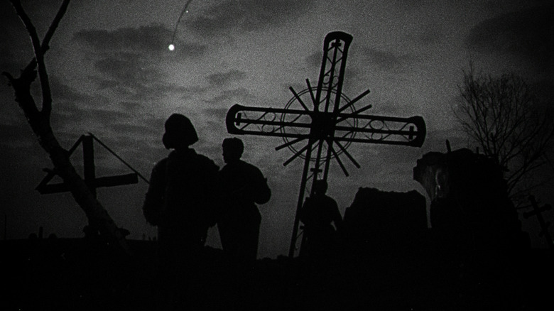 Figures silhouetted against a cross