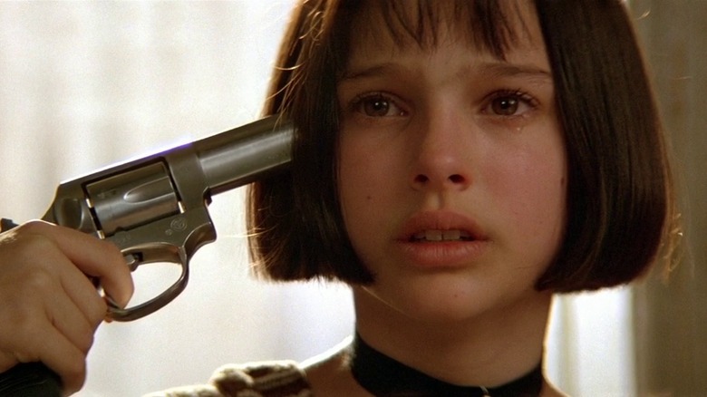 Mathilda holding gun to head