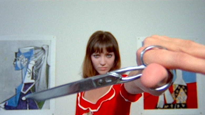 Anna Karina holding scissors