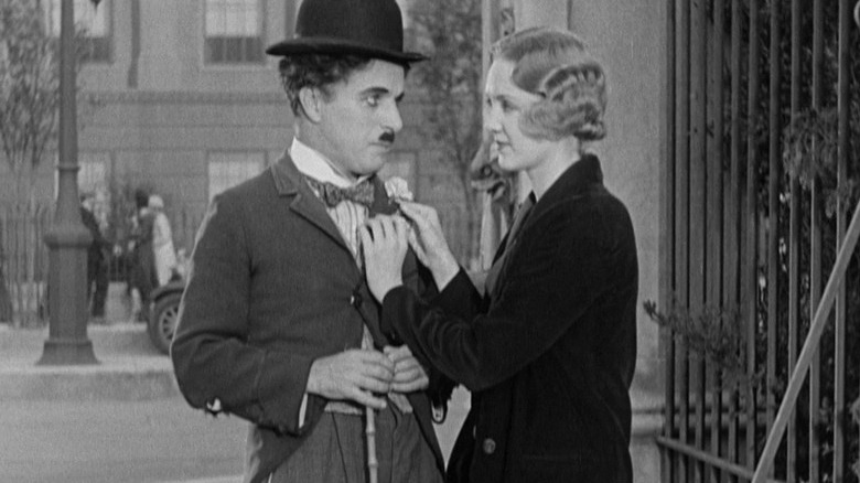 Girl pins flower on Charlie Chaplin