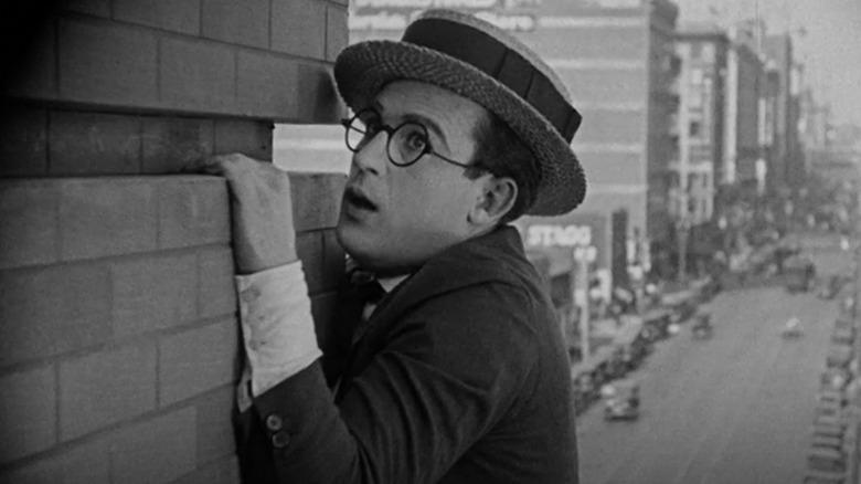 Harold Lloyd dangles from building