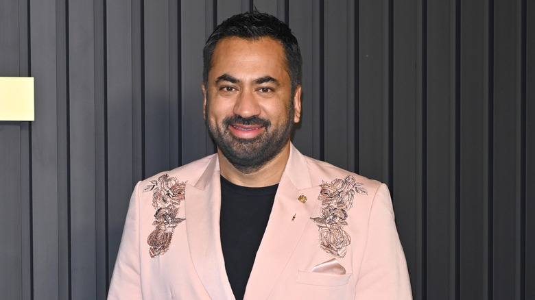 Kal Penn smiling on a red carpet