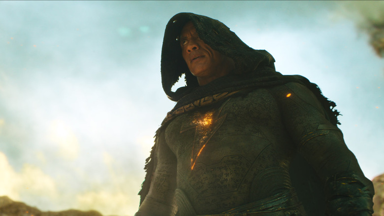 A hooded Black Adam stares intensely in a desert