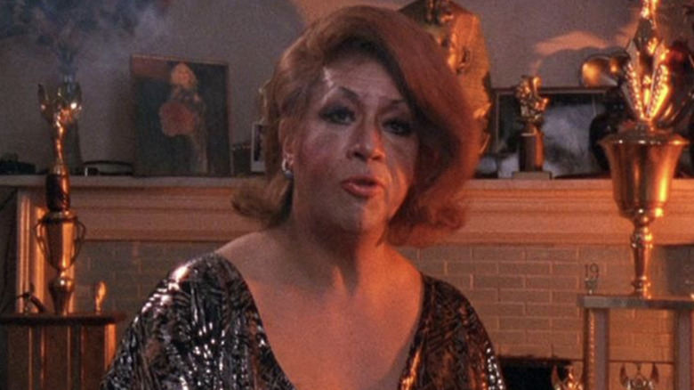 Dorian Corey sits in front of trophies