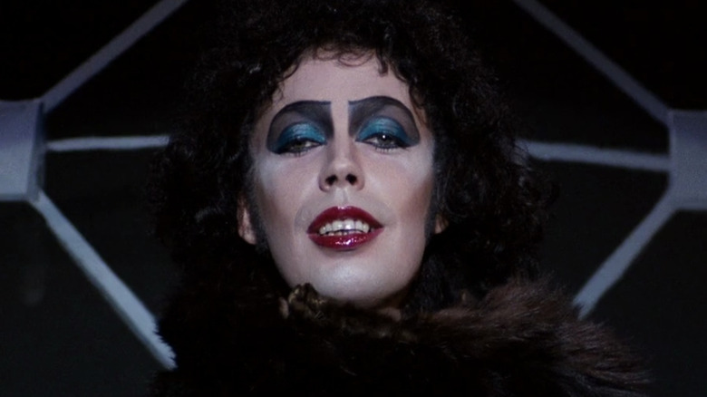 Tim Curry half smiles at camera