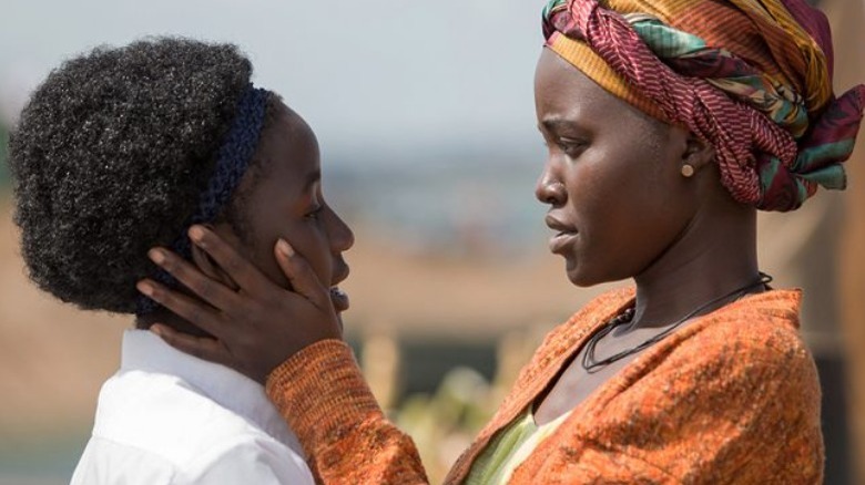 Lupita Nyong'o holds young woman's face