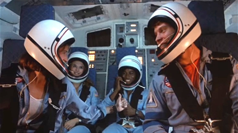 Teenagers sitting inside a space shuttle