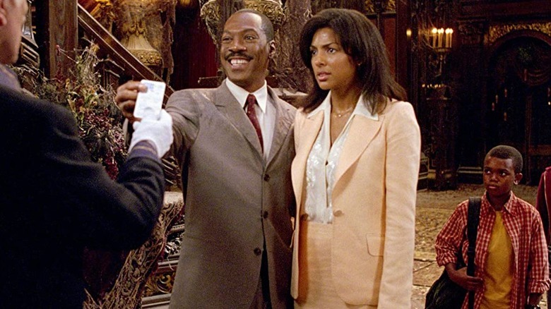 Eddie Murphy smiling next to woman