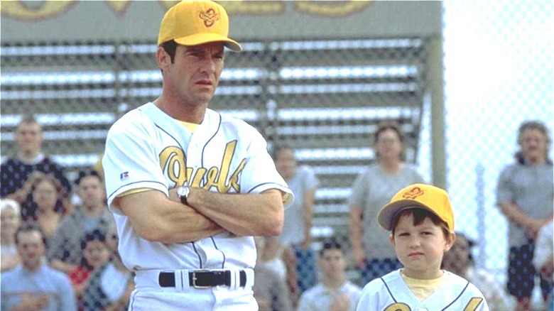 Dennis Quaid crosses arms next to kid