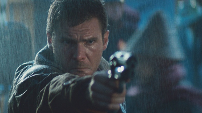 Rick Deckard pointing a gun in the rain