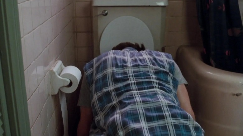 Ace Ventura vomiting into a toilet