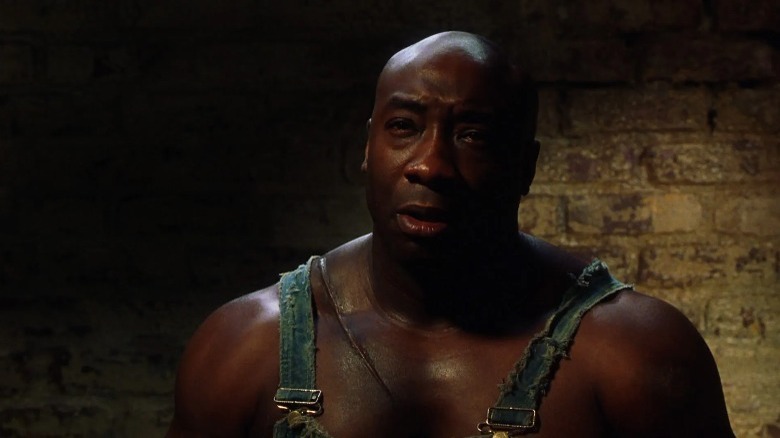 John Coffey standing and frowning