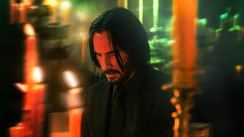 John Wick kneels before candle