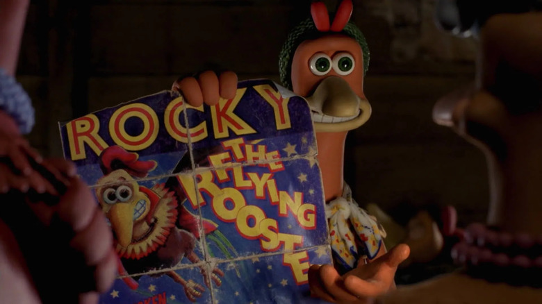 Ginger holding Rocky's poster up while grinning