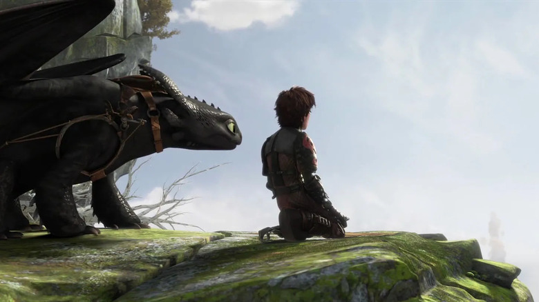 Older Hiccup and Toothless looking over cliff