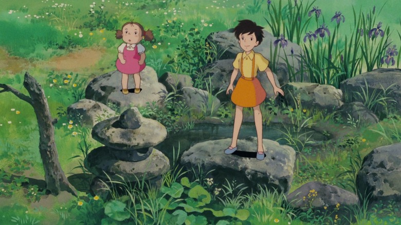 Mei and Satsuki standing on rocks near pond