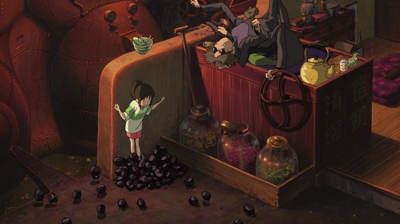 Soot Sprites surrounding Chihiro with coal in Kamaji's boiler room