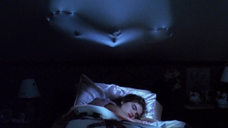 Heather Langenkamp sleeps under hands pushing through ceiling