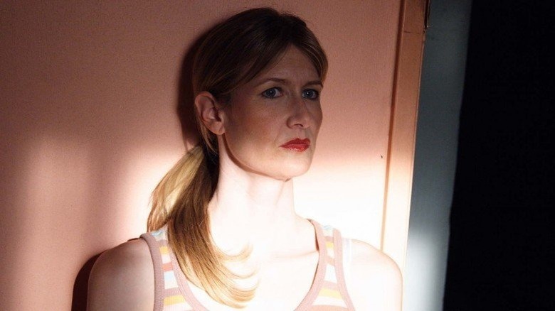 Laura Dern concerned leans against wall