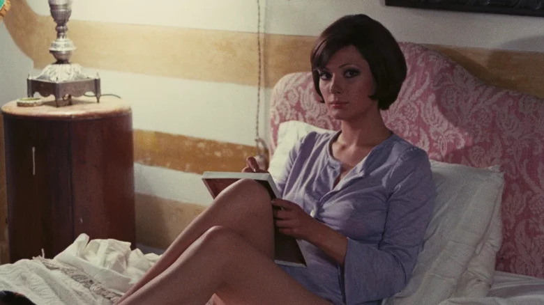 Edwige Fenech side eyes and writes in notebook