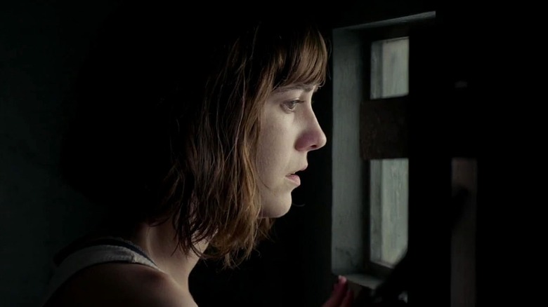 Mary Elizabeth Winstead peers out the bunker window in 10 Cloverfield Lane