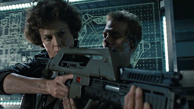 Sigourney Weaver as Ellen Ripley holds a pulse rifle in Aliens