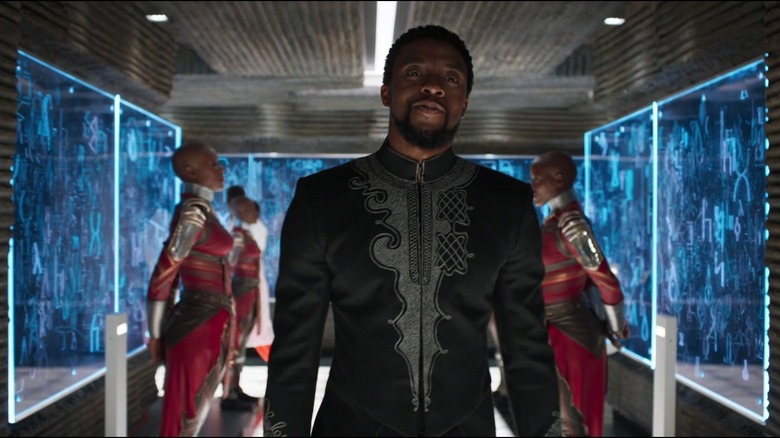 T'Challa enters his sister's laboratory flanked by Dora Milaje guards in Black Panther