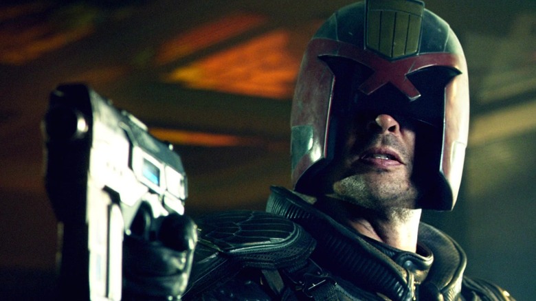 Karl Urban as Judge Dredd, aiming his pistol in 2012's Dredd