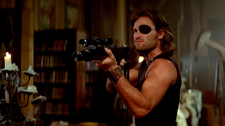 Snake Plissken (Kurt Russell) aims a rifle in Escape from New York