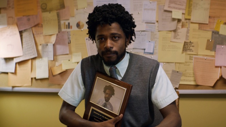 LaKeith Stanfield as Cash Green holding his Employee of the Month plaque in Sorry to Bother You