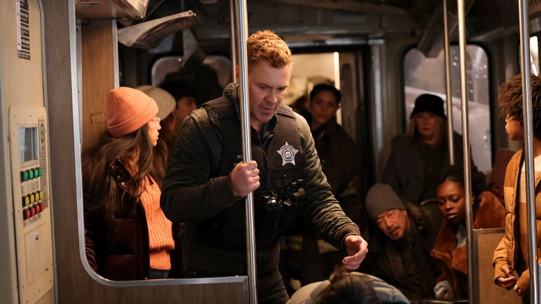 Adam Ruzek holding onto a pole on a train on 