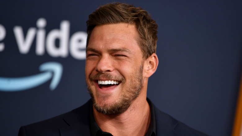 Alan Ritchson smiling at event