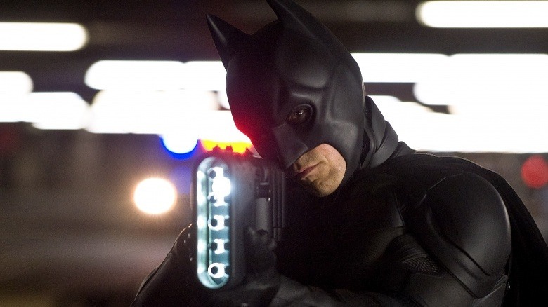 Batman holds weapon