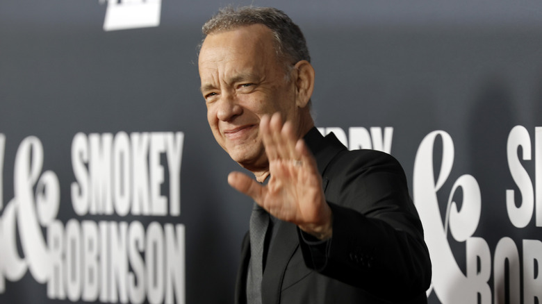 Tom Hanks smiling and waving