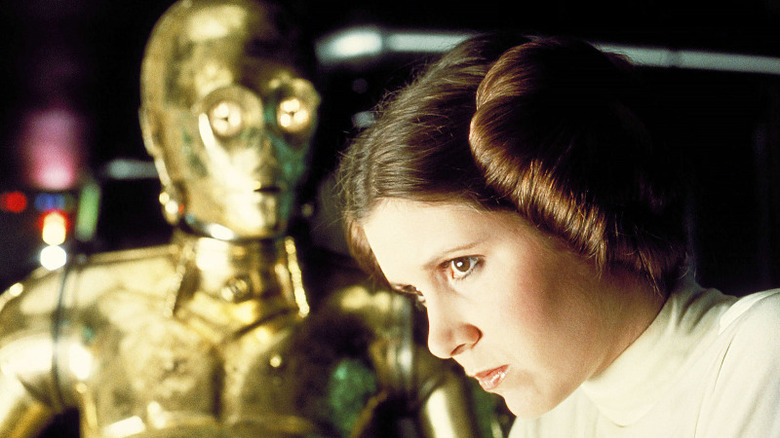 C-3PO worriedly watches Leia