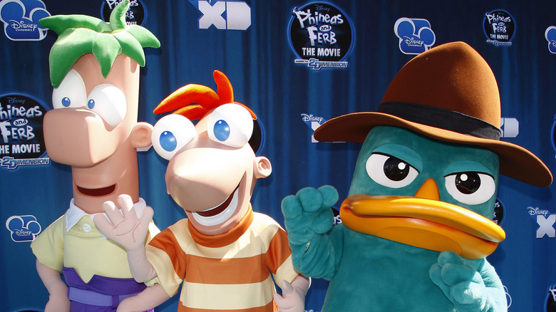 Three performers in Ferb, Phineas, and Perry the Platypus costumes 