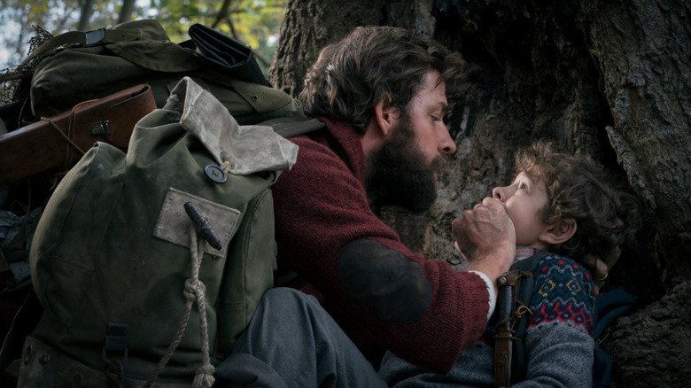 Lee hiding behind a tree with his son