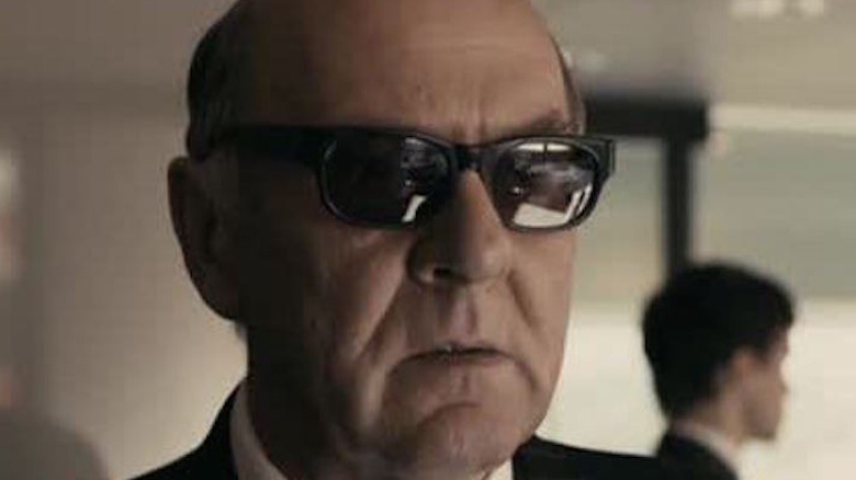 Tom Wilkinson wears sunglasses.