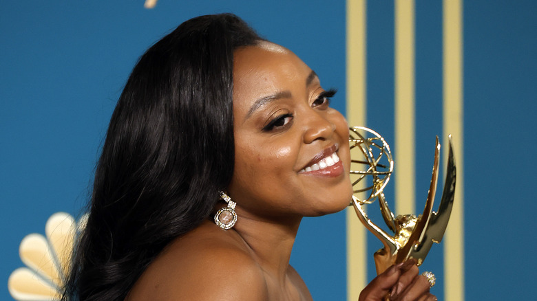 Quinta Brunson smiling holding her Emmy