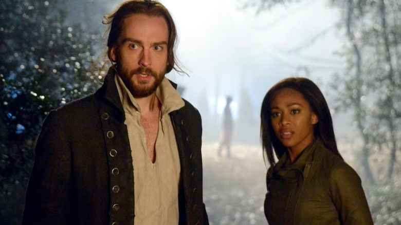 Ichabod Crane and Abbie Mills stand in a forest on "Sleepy Hollow"