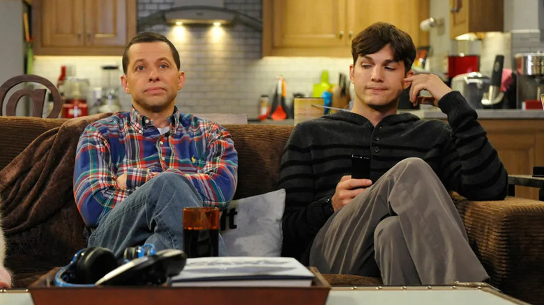 Walden and Alan sit on the couch together in "Two and a Half Men"